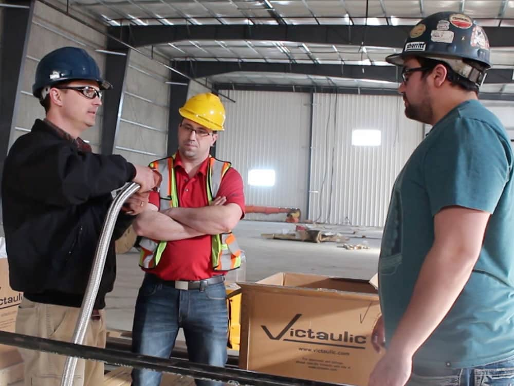 Three Workers Discussing a Project with Victaulic Products