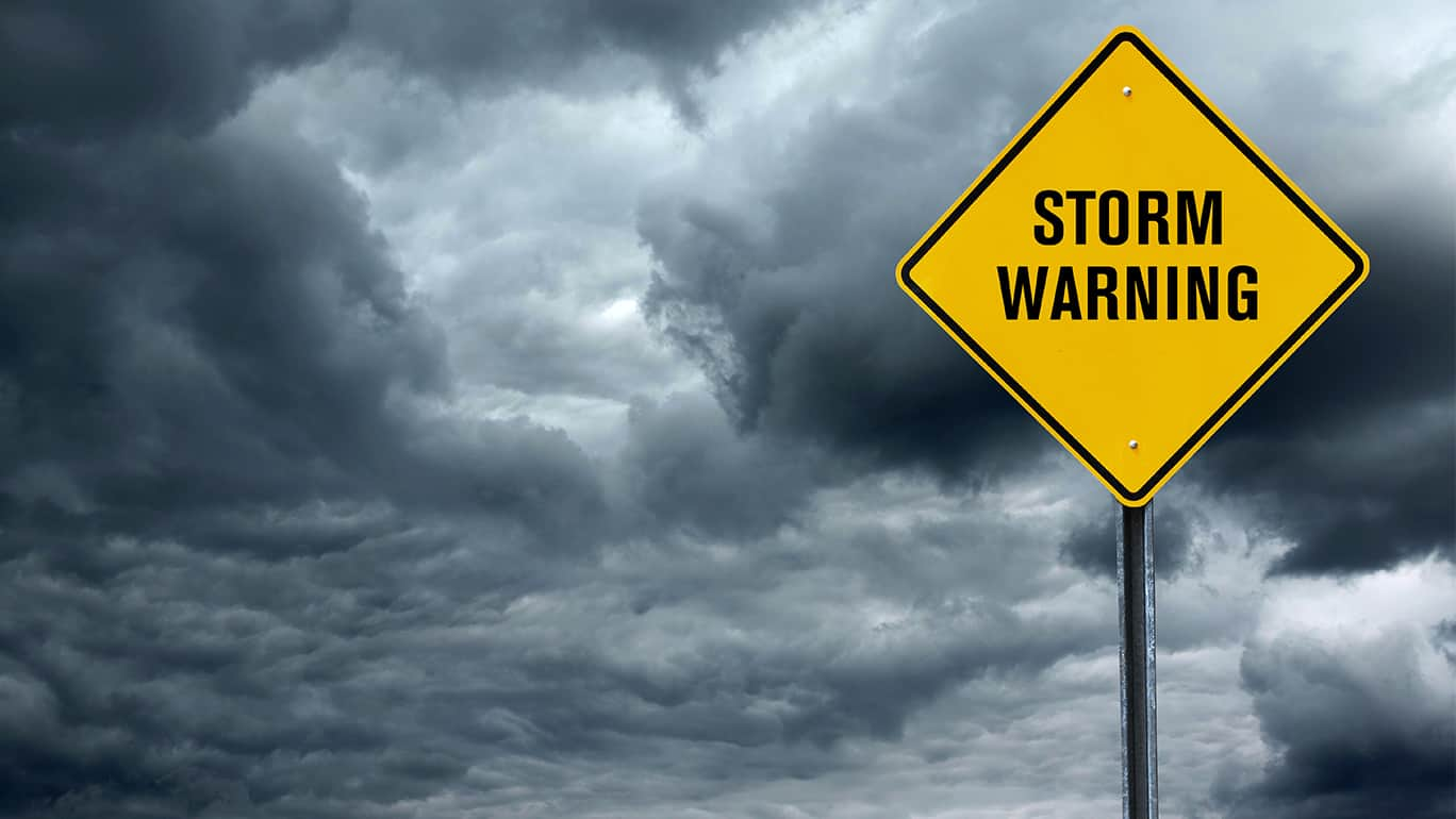 blank road warning sign in front of storm cloud background