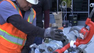 Fire protection system installer working with a Victaulic roll grooving pipe tool