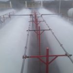 Style V12 open spray nozzles distributing water across surface of tanks