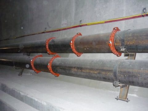 Dos tuberías de transmisión que corren a lo largo de la pared del túnel